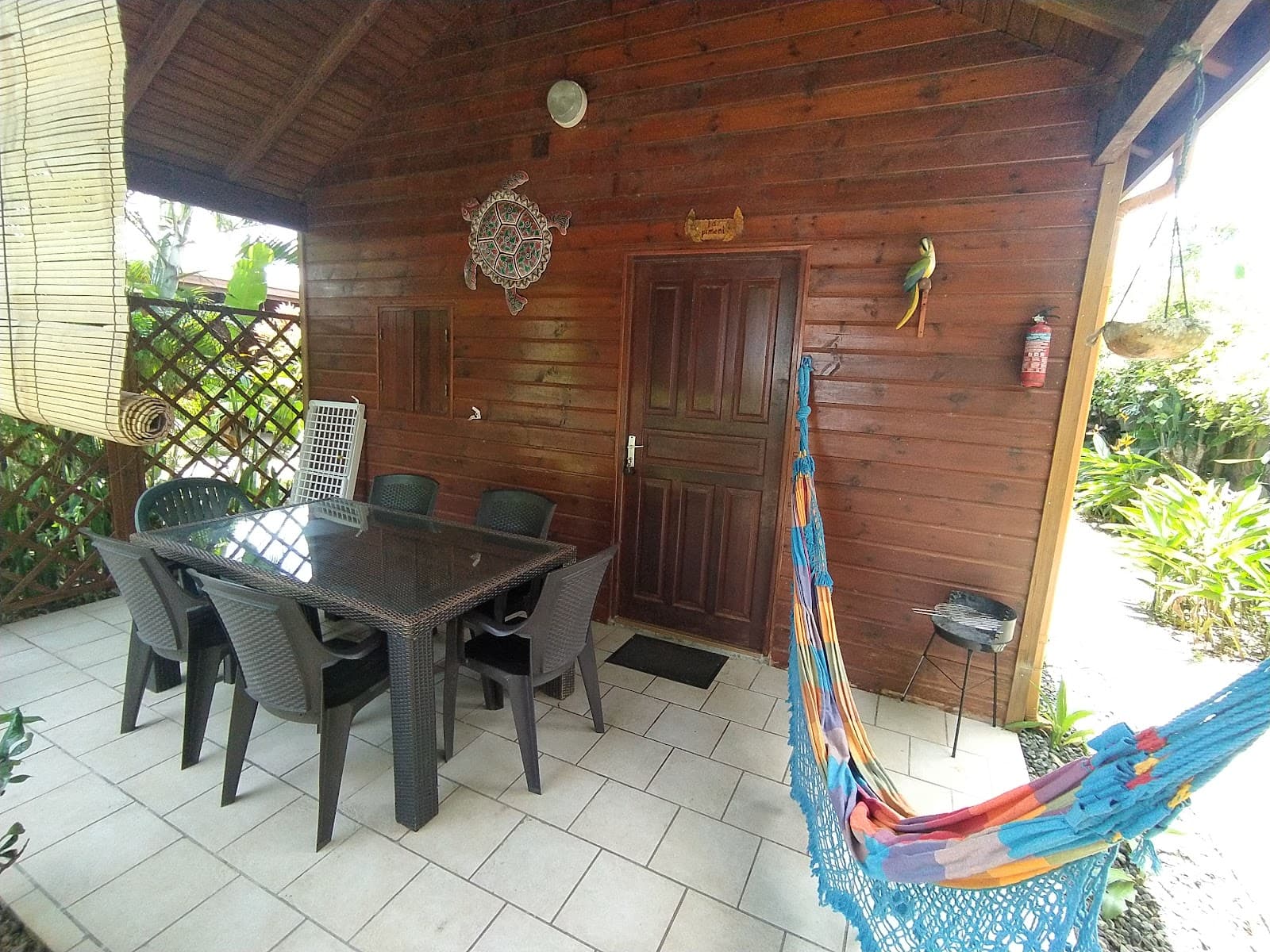 Terrasse couverte du bungalow en bois avec son hamac