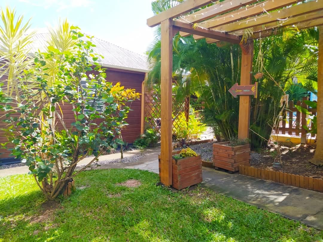 La propriété et sa pergola au milieu des plantes tropicales